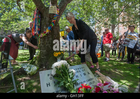 London, UK. 6. August 2016. Menschen legen Blumen an der Festschrift Kirschbaum bei der CND-Zeremonie im Gedenken an die Opfer vorbei und präsentieren auf der 71. Jahrestag der Atomic bomb auf Hiroshima und die zweite Atombombe über Nagasaki abgeworfen, drei Tage später. Peter Marshall/Alamy Live-Nachrichten Stockfoto