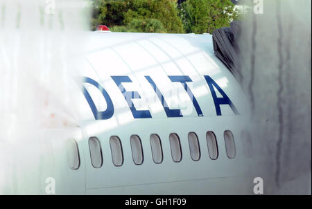 Orlando, Florida, USA. 8. August 2016.  Ein Delta Airlines Flugzeug wird auf dem Asphalt durch eine beschlagene Fenster am Orlando International Airport als weltweit alle Flüge am frühen Morgen durch ein Herunterfahren des Computer Systems geerdet wurden gesehen. Bildnachweis: Paul Hennessy/Alamy Live-Nachrichten Stockfoto