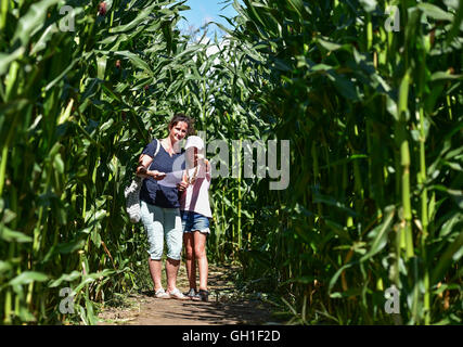 Storkow, Deutschland. 8. August 2016. Die Otten-Familie aus Berlin ist unterwegs in einem Mais-Ernte-Labyrinth in der "Irrlandia" von der Mitmachparks in Storkow, Deutschland, 8. August 2016. Im Freizeitpark Irrlandia Besucher können nicht nur im Labyrinth verloren gehen, sondern auch versuchen, Rollenschlitten, Baumhäuser und Kette Treppen. Letzte Saison gab es 75.000 Besucher. Foto: PATRICK PLEUL/DPA/Alamy Live-Nachrichten Stockfoto