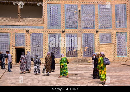 Usbekische Frauen gehen in den Hof des Palastes Tosh Hovli in Chiwa, Usbekistan Stockfoto