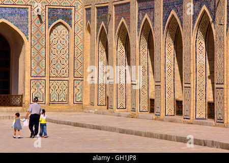 Eine usbekische Mann mit seinen beiden Kindern zu Fuß in den Hof der Poy Kalon Moschee in Buchara, Usbekistan Stockfoto