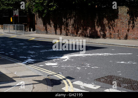 Auto-Reifenspuren auf Straße von verschüttetem weiß malen England uk Stockfoto