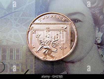 Zwei Pence Münzen auf zwanzig Pfund-Note, London Stockfoto