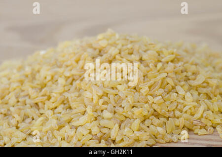 Rohe Bulghur Grütze auf Holztisch Stockfoto