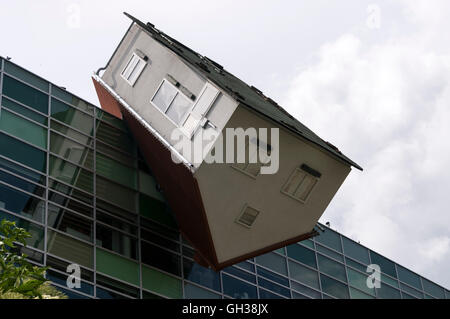 Ein Modellhaus, das schräg auf dem Bürogebäude der STRABAG Inc mit Sitz in Mlynské nivy, Bratislava, Slowakei, aufgestellt wurde Stockfoto