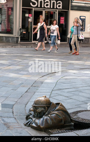 Eine Bronzeguss-Statue eines Cumil, eines Mannes, der in Panska in der Altstadt von Bratislava, Bratislava, Slowakei, einen Schachtloch blickt. Es gibt keine Stockfoto