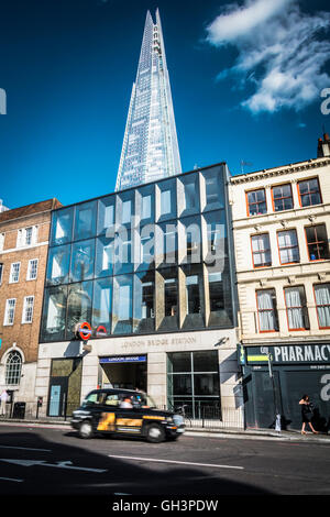 London, England, Vereinigtes Königreich: Ein paar gehen in der Sonne in der Nähe der Scherbe in Southwark. Stockfoto