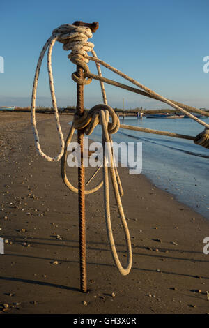 Ein Seil eines Bootes ist Krawatte mit Eisen Pfahl am Strand Stockfoto