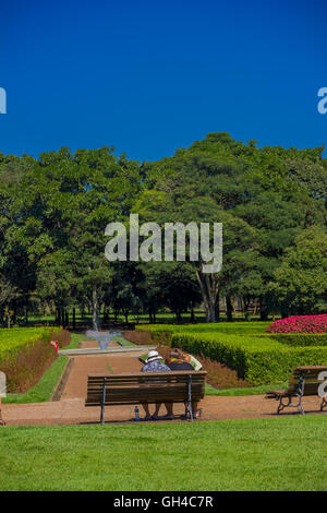 CURITIBA, Brasilien - 12. Mai 2016: Menschen ruht auf einer Bank am geometrischen Gärten des botanischen Parks der Stadt Stockfoto