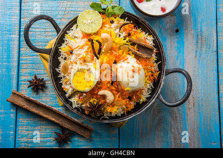 Basmati-Reis langsam gekocht, mit Masala gebratenes Ei und Gewürzen serviert in Kadhai oder Kadai mit Joghurt-Dip, selektiven Fokus Stockfoto