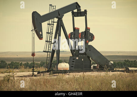 Arbeitende Pumpe Jack ziehen Rohöl aus einer Ölquelle in Colorado, USA. Retro-Instagram aussehen. Stockfoto