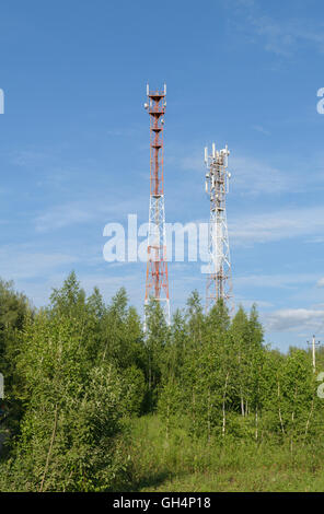 Zwei Türme mit einer zellulären Mobilfunk-Antennen sind unter den Bäumen Stockfoto