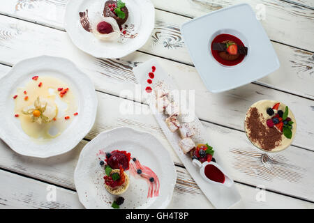 Verschiedene Desserts auf Tellern anrichten. Stockfoto