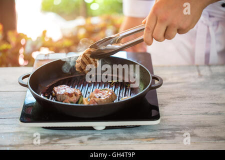 Zange halten Stück Fleisch. Stockfoto