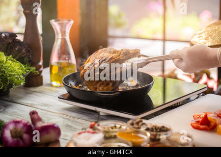 Zange halten gebratenen Fleisch. Stockfoto