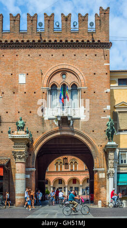 Radfahrer und Menschen, die über den Platz Piazza del Municipio mit der herzoglichen Schloss Estense, jetzt Guildhall, in Ferrara, Italien Stockfoto