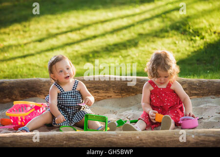 Die beiden baby wenig Mädchen spielen Spielzeug in sand Stockfoto