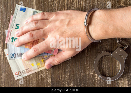 Hand in Handschellen auf Eurobanknoten Stockfoto