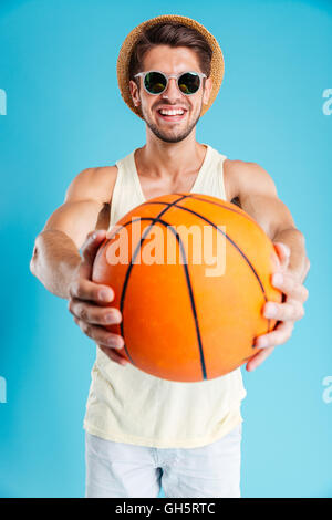 Glücklich, junger Mann in Hut und eine Sonnenbrille, geben Sie einen Basketball-ball Stockfoto