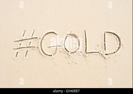 Hashtag-social Media-Nachricht für Gold geschrieben im Sand am Strand von Rio De Janeiro, Brasilien Stockfoto