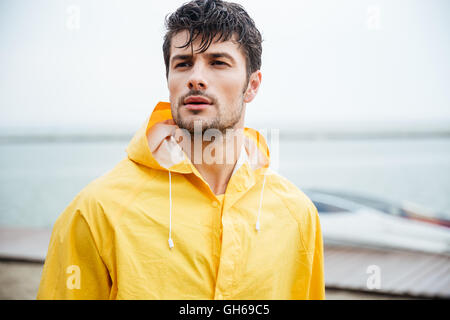 Porträt eines schönen jungen Matrosen in gelben Mantel hautnah Stockfoto