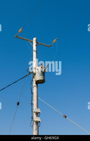 11kv zweiphasige Stromkabel und ein Abschalttransformator auf einem Holzmast. Stockfoto