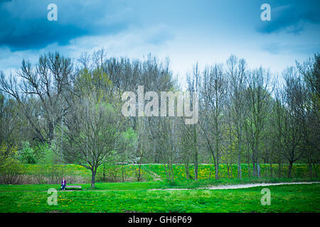 einsame Frau sitzen auf einer Bank in der Natur Stockfoto