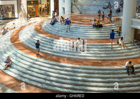 Besucher sitzen auf die geschwungene Marmortreppe hinab in den Wintergarten Atrium von Brookfield Place in Lower Manhattan Stockfoto