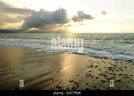 Meer Sonnenuntergang ist einige dramatischen Wolken über den Ozean als eine helle Reihe von Sonnenstrahlen durch die Dunkelheit zum Licht th platzen Einzug Stockfoto