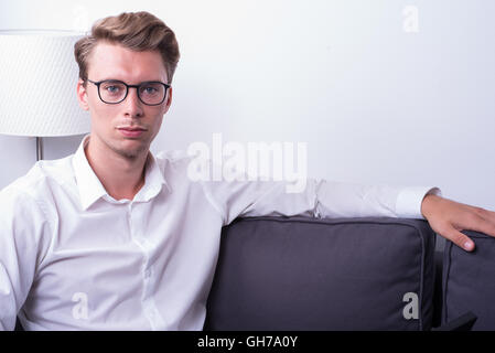 schönen jungen Mann zu Hause auf der Couch entspannen Stockfoto