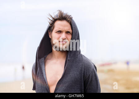 Hipster-Mann am Strand tragen Sweatshirt mit Kapuze, sonnigen Sommer Stockfoto