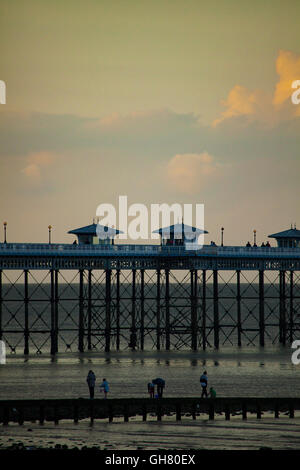 Einen warmen Sommerabend in Llandudno mit Besucher genießen den Abend im Resort. Besucher der Kurstadt genießen Krabbe Angeln in der Abenddämmerung mit den majestätischen Llandudno Pier als Back-drop Stockfoto