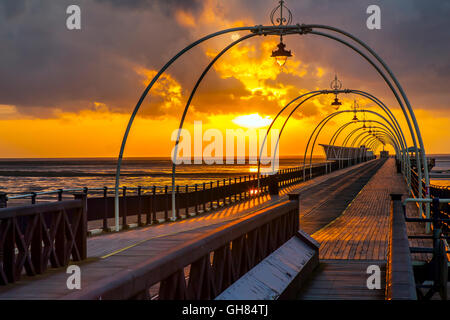 Southport, Merseyside, England Wetter. 9. August 2016.  Sonnenuntergang über den Pier in Southport nach einem Tag mit starkem Wind, stürmischen und schwere Regen mit seltsame Wolkenformationen.  Bildnachweis: MediaWorldImages/Alamy Live-Nachrichten Stockfoto