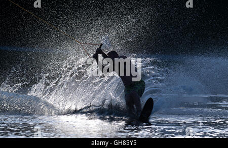 München, Deutschland. 8. August 2016. Ein Wakeboarder wird über den Olympiasee durch Seil im Licht der Abendsonne in München, Deutschland, 8. August 2016 gezogen. Foto: SVEN HOPPE/Dpa/Alamy Live News Stockfoto