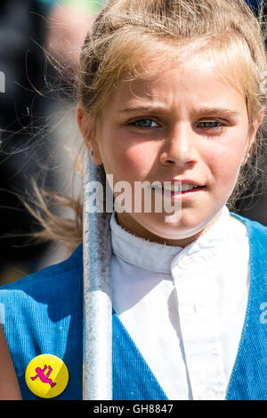 Broadstairs folk Woche Festival. Close-up, junge Teenager blond Royal Liberty Morris Mädchen Tänzer, 11-13 Jahre alt, der Viewer. Kopf und Schultern. Helles Sonnenlicht auf dem Gesicht, halb lächelnd. Stockfoto