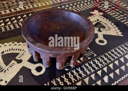 Antike Samoan tanoa oder laulau kava Schüssel aus Holz geschnitzt. Samoan Tapa Tuch unter Glas auf dem Tisch. Stockfoto