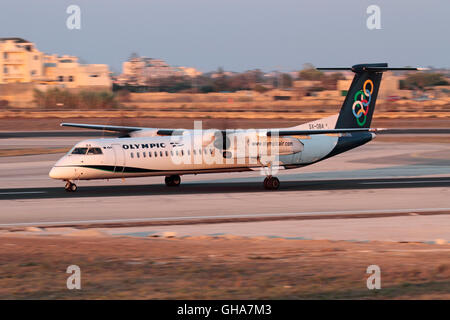 Olympic Air Bombardier Dash 8-Q400 Propellerflugzeug, das bei Sonnenuntergang abfliegt. Langsame Verschlusszeit zum Schwenken, Verwacklungen der Requisiten. Start des Turboprop-Flugzeugs. Stockfoto