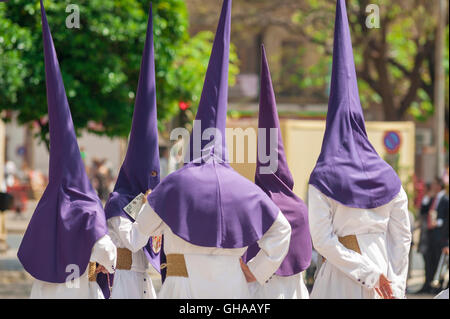 Sevilla Spanien Karwoche, Mitglieder einer cofradia mit Kapuze (Bruderschaft) versammeln sich vor einer Prozession in der Semana Santa Festival in Sevilla, Spanien. Stockfoto