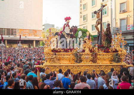 Sevilla Spanien Ostern, Blick auf einen riesigen Wagen, der eine Kreuzigungsszene zeigt, die durch die Straßen von Sevilla beim Semana Santa Festival in Spanien läuft Stockfoto