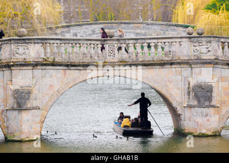 An einem frühen Frühlingsmorgen in Cambridge, UK machen Sie Touristen einen Ausflug in einem Kahn auf dem Fluss Cam gleiten unter Clare Bridge. Stockfoto