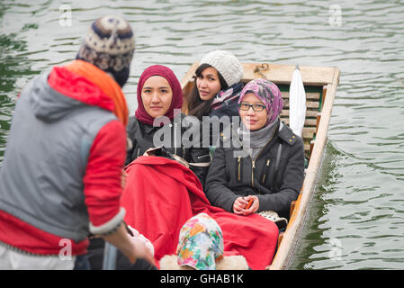 An einem frühen Frühlingsmorgen in Cambridge, UK Touristen machen Sie einen Ausflug in einem Kahn auf dem Fluss Cam. Stockfoto