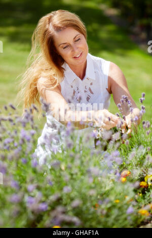 Frau trimmen Blumen im freien Stockfoto