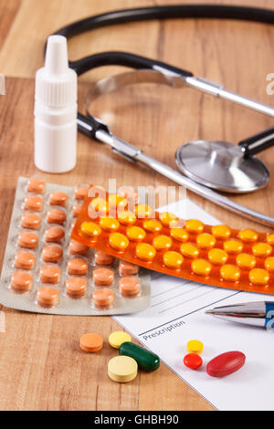 Medizinische Pillen, Tabletten oder Ergänzungen für Therapie, Rezept und Stethoskop auf Schreibtisch im Büro des Arztes, Behandlungskonzept, Stockfoto