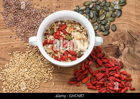 Haferflocken mit Goji-Beeren, Leinsamen, Pumpkinseed. Müsli-Frühstück auf hölzernen Hintergrund. Gesunden superfoods Stockfoto