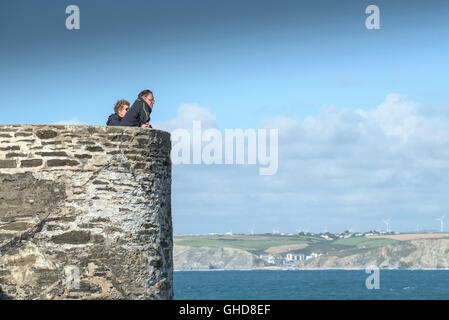 Urlauber stehen auf einer Aussichtsplattform auf den Towan Strand in Newquay, Cornwall. Stockfoto