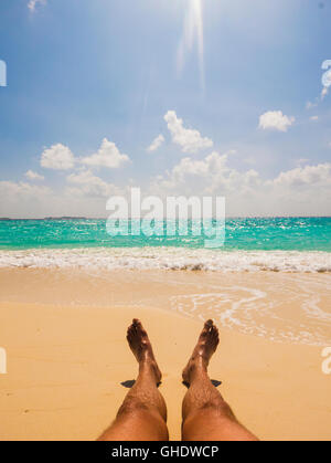 Mann an sonnigen tropischen Strand Sonnenbaden Stockfoto