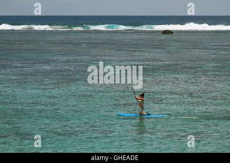 Mädchen an Bord mit einem Ruder. Lagune Hermitage, Reunion Stockfoto