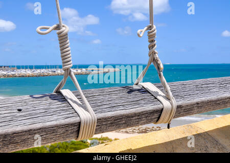 Zwei Seil Schlüsselband Flaggenleinen gebunden, um Holzgeländer mit dem indischen Ozean Seelandschaft und Marina in Fremantle, Western Australia Stockfoto