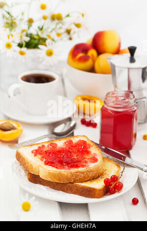 Frühstück: frisches Toast mit hausgemachte rote Johannisbeere Marmelade, Kaffee und Obst Stockfoto