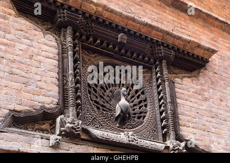 Bhaktapur, Nepal - 4. Dezember 2014: Ein schön geschnitzte Fenster aufgerufen Fenster Pfau Stockfoto